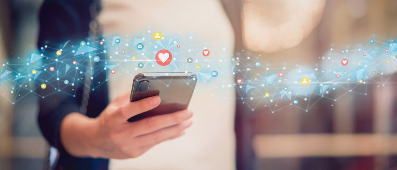 Influenceur déterminant ses prix avec une calculatrice et une liste de tarifs devant un ordinateur affichant des statistiques de réseaux sociaux