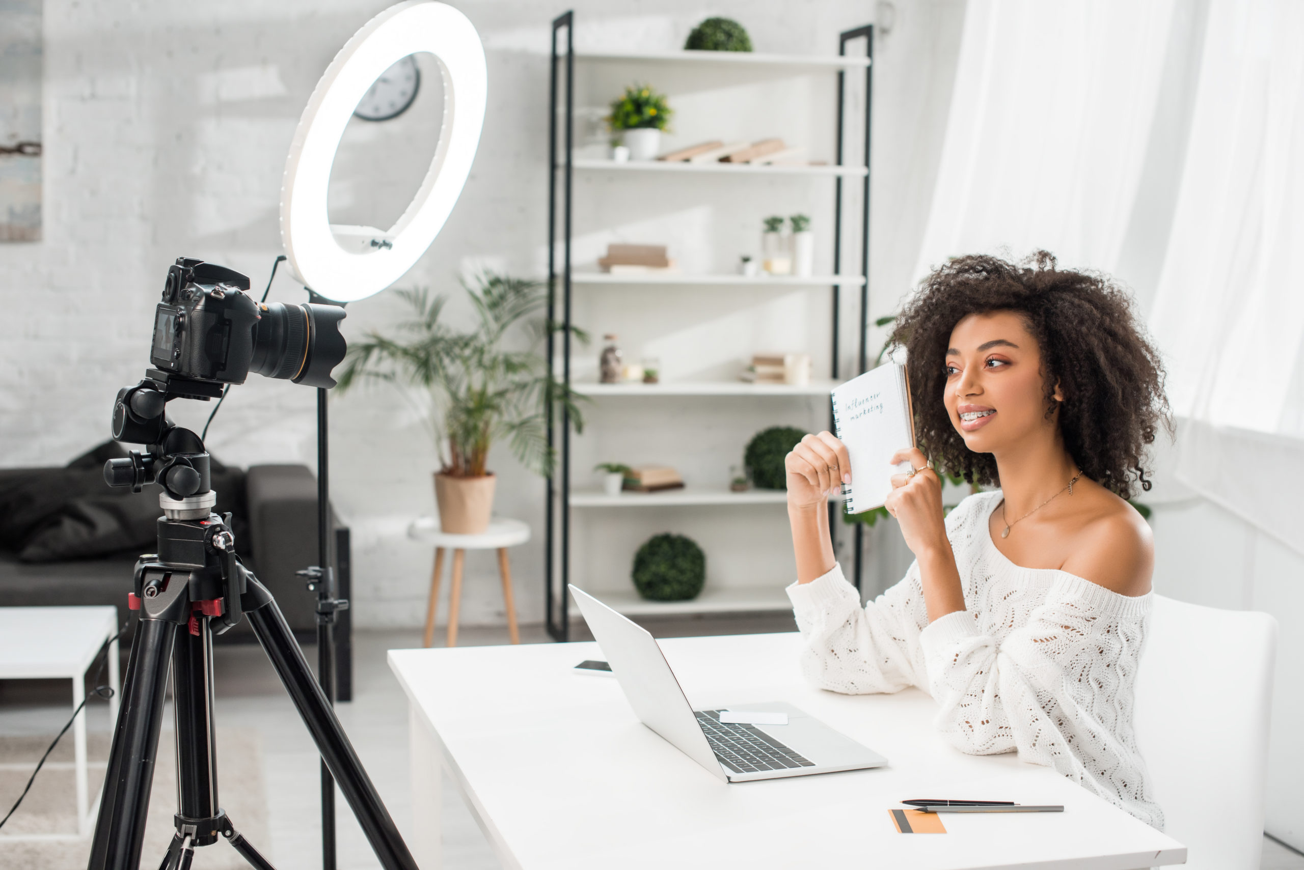 Femme influenceuse créant du contenu viral sur les réseaux sociaux avec un smartphone et des accessoires tendance